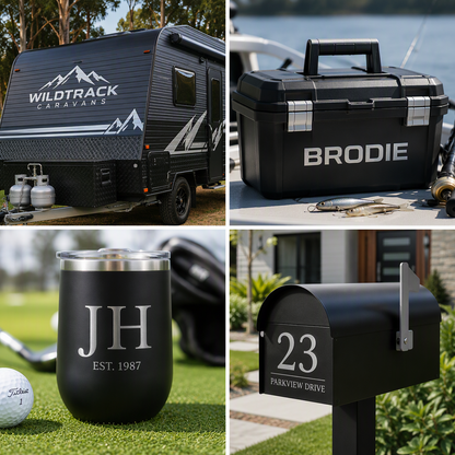 A four-panel collage showing customized black products with silver gloss adhesive vinyl: a Wildtrack Caravans travel trailer outdoors, a black hard case with 'BRODIE' engraved on it next to water, a black insulated tumbler with 'JH EST. 1987' engraved on a golf course, and a black mailbox with the address '23 PARKVIEW DRIVE' in a suburban setting.